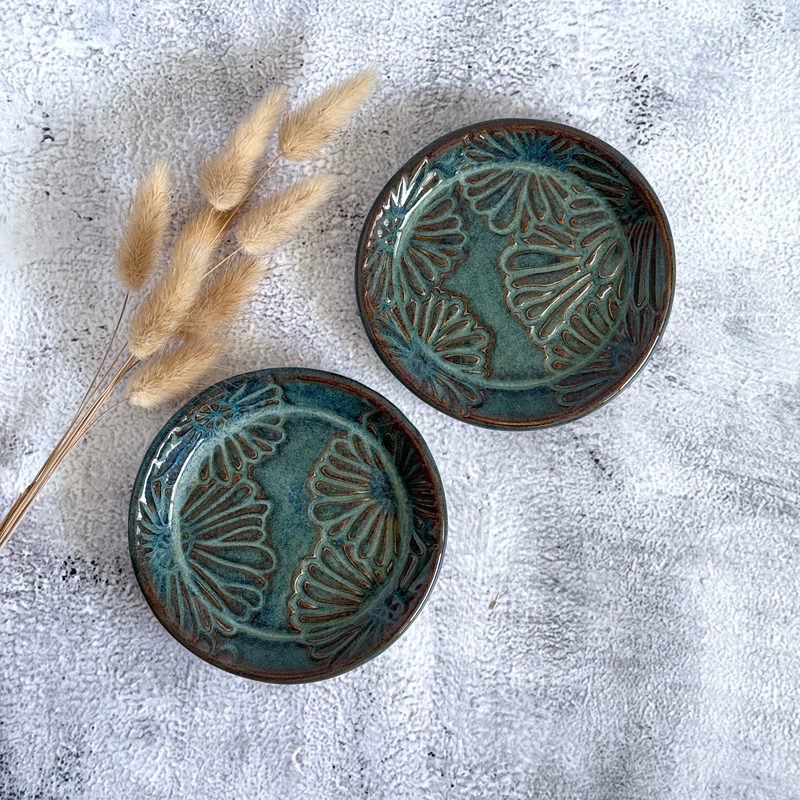 Two teal bowls with leaf pattern and pampas.