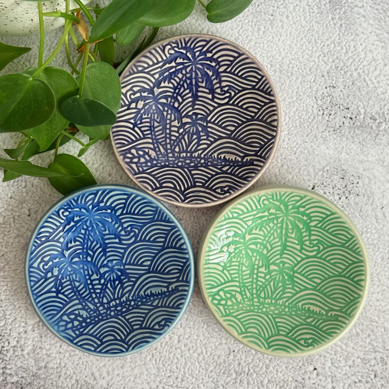 Three patterned round plates in navy, blue, and green.